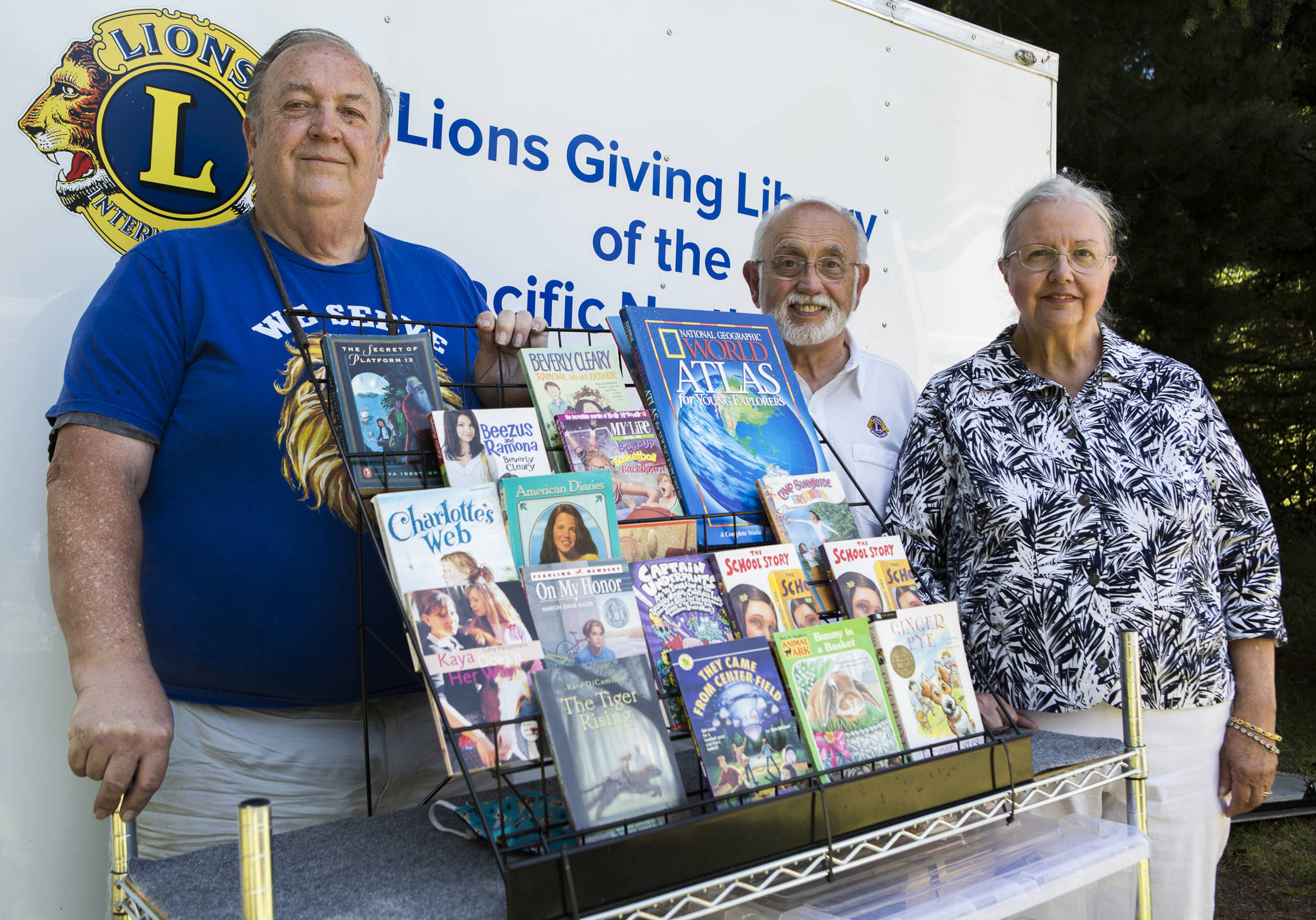 Lions Club members Michael Lally (left), Art Ruben and Judith Ruben with a selection of their donated books on Tuesday in Tulalip. (Olivia Vanni / The Herald)