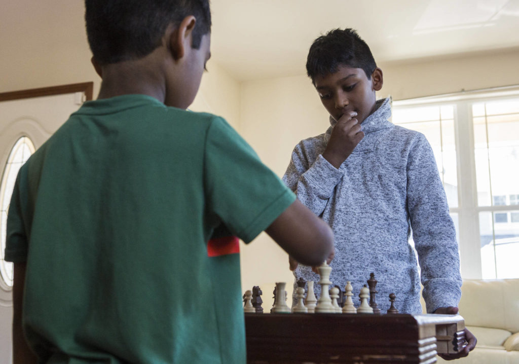 Keshav Beegala (right) plays a practice chess match with his brother Dhruv, 6, in Bothell. (Olivia Vanni / The Herald)
