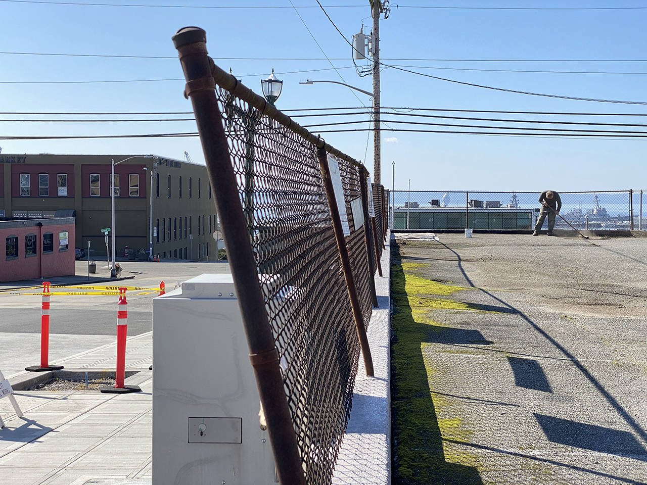 A man sweeps a parking lot in north Everett. (Sue Misao / Herald file)
