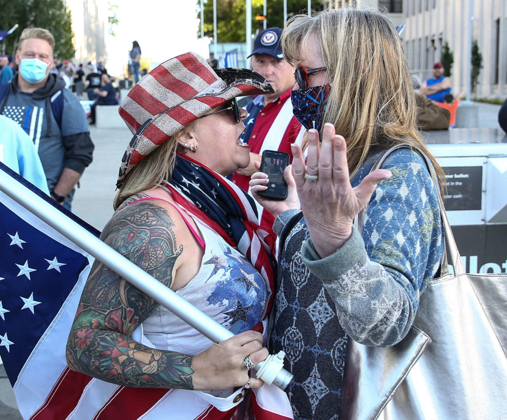 A supporter (left) and a protester face off during the rally to support law enforcement and first responders sponsored by The Outreach Committee of the Snohomish County Republican Party Friday at the Snohomish County Plaza in Everett on July 17, 2020. (Kevin Clark / The Herald)
