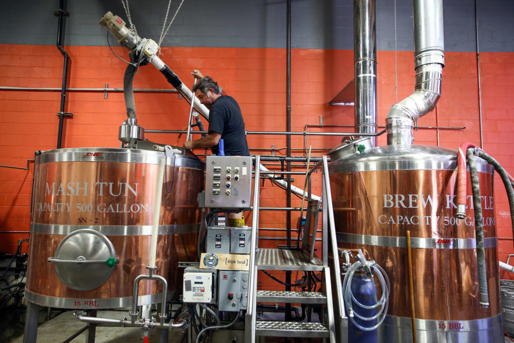 Shawn Loring, owner of Lazy Boy Brewing, works the vats at his shop Saturday afternoon in Everett. (Kevin Clark / The Herald)
