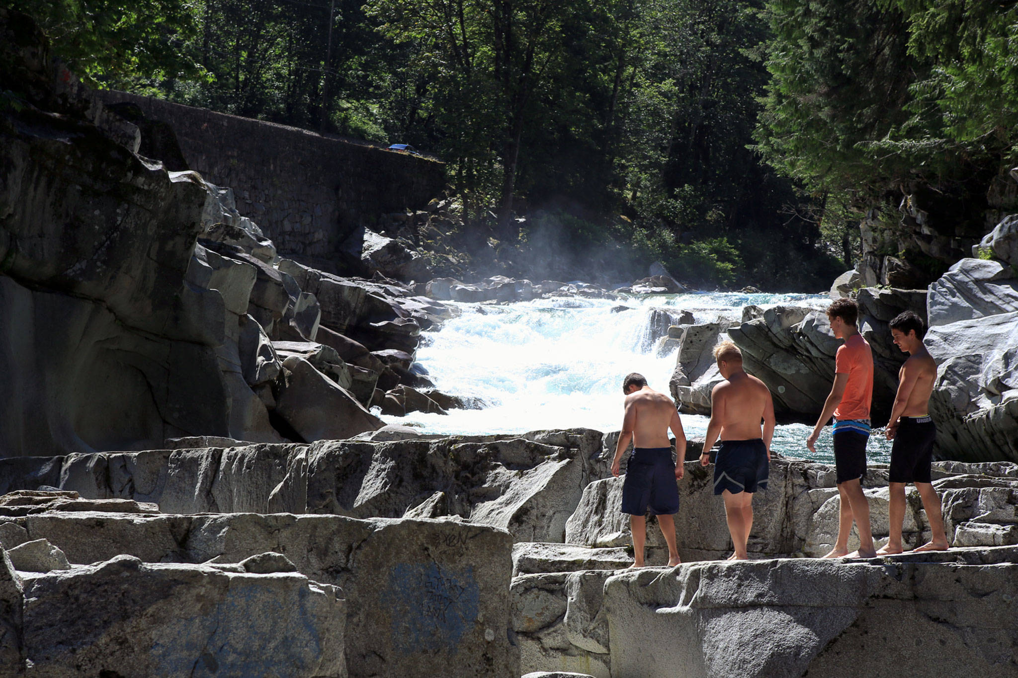 Collin Strobeck, Bostin Otto, Johnny Marcello and Ian Vincent make their way over the landscape of Eagle Falls on the Skykomish River on July 14, 2016, just outside Index. (Kevin Clark / Herald file)