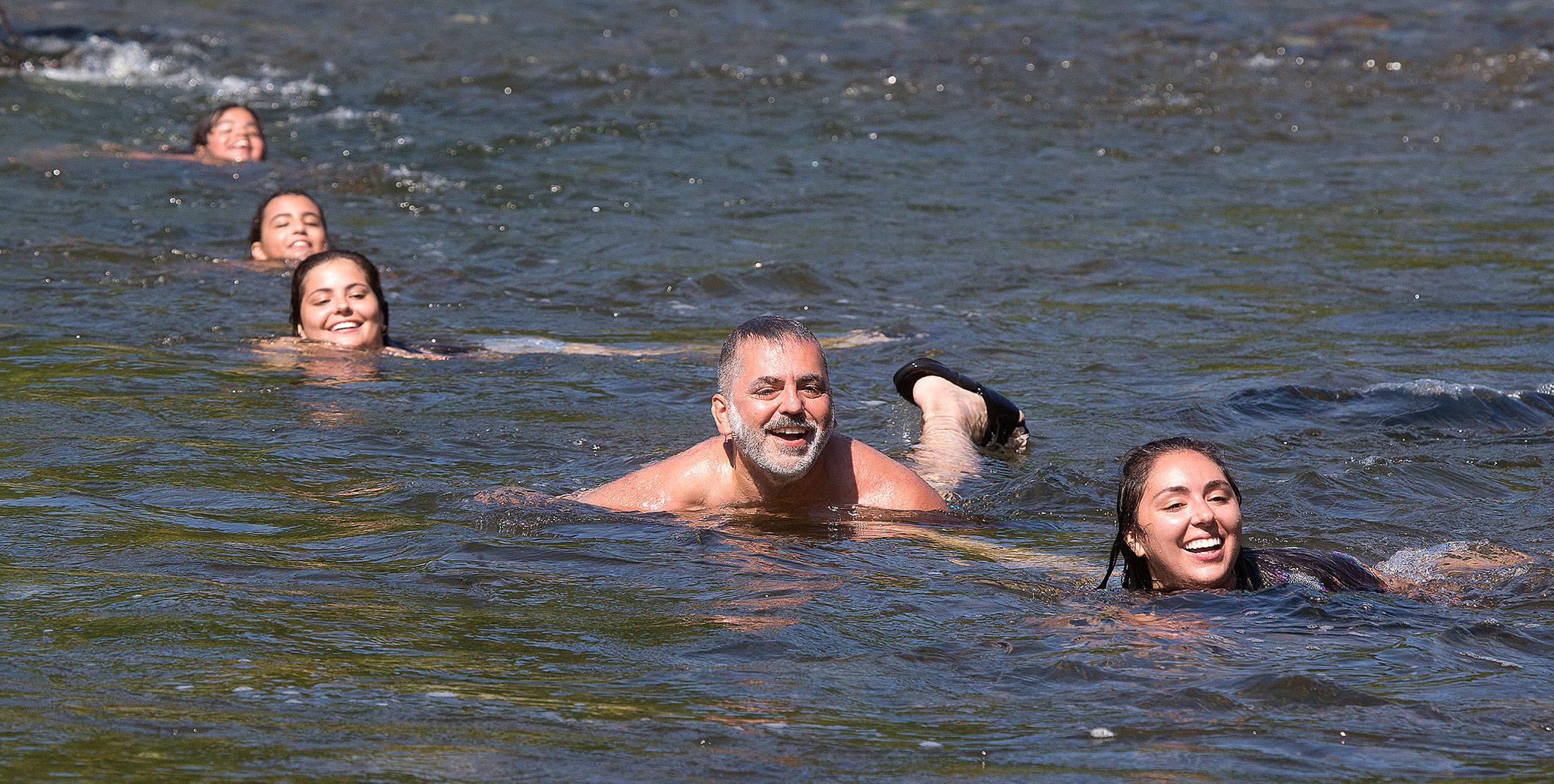 Like father, like daughters: Walid Joudi (center) swims in the Pilchuck River with daughters (from left) Sophia, Isabelle, Gabrielle and Hannah on Tuesday in Snohomish. (Andy Bronson / The Herald)