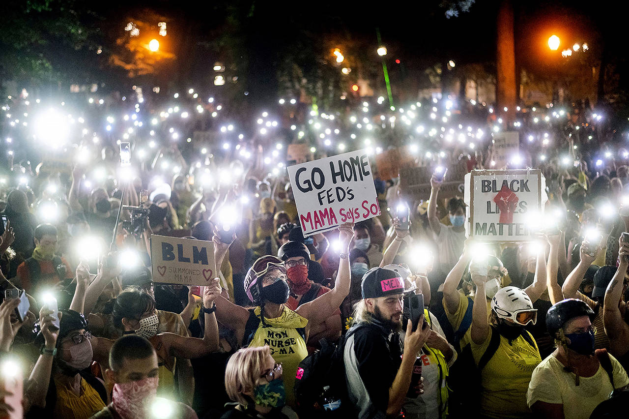 Hundreds of Black Lives Matter protesters hold their phones aloft on Monday in Portland, Oregon. (AP Photo/Noah Berger)