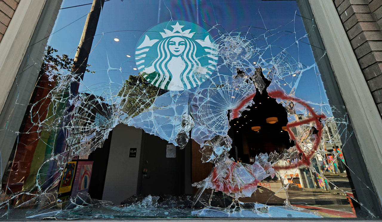 Broken windows are shown at a Starbucks store on July 19 in Seattle’s Capitol Hill neighborhood. Protesters broke windows at the store earlier in the afternoon. (AP Photo/Ted S. Warren)