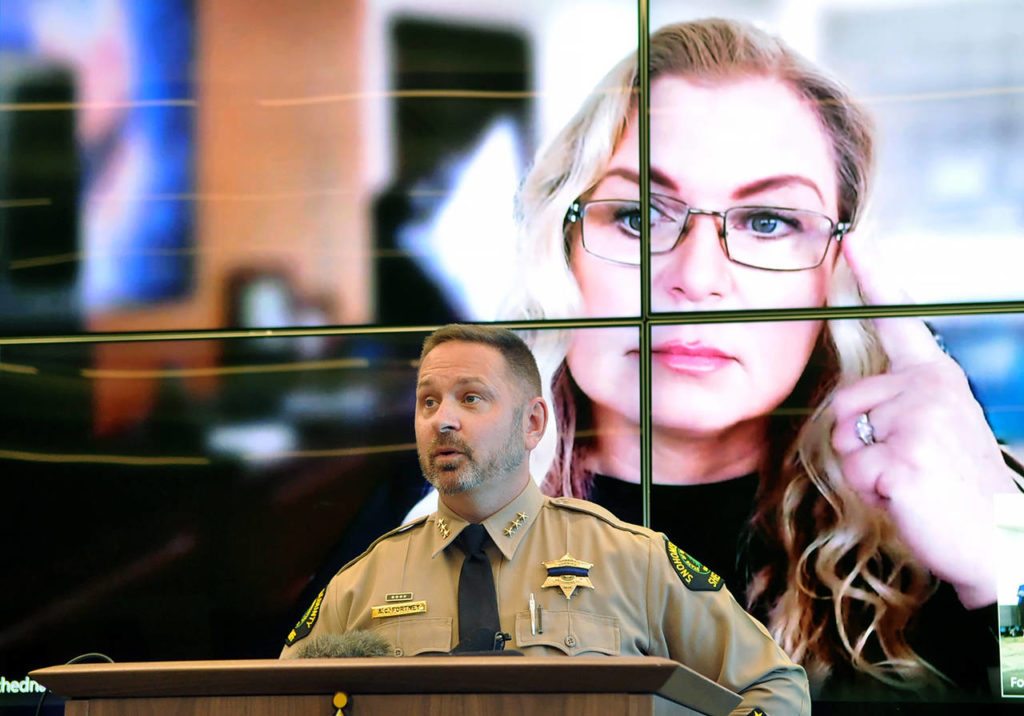 Snohomish County Sheriff Adam Fortney speaks to media Wednesday, with genetic genealogist CeCe Moore participating over Skype on the screen behind him. (Sue Misao / The Herald)
