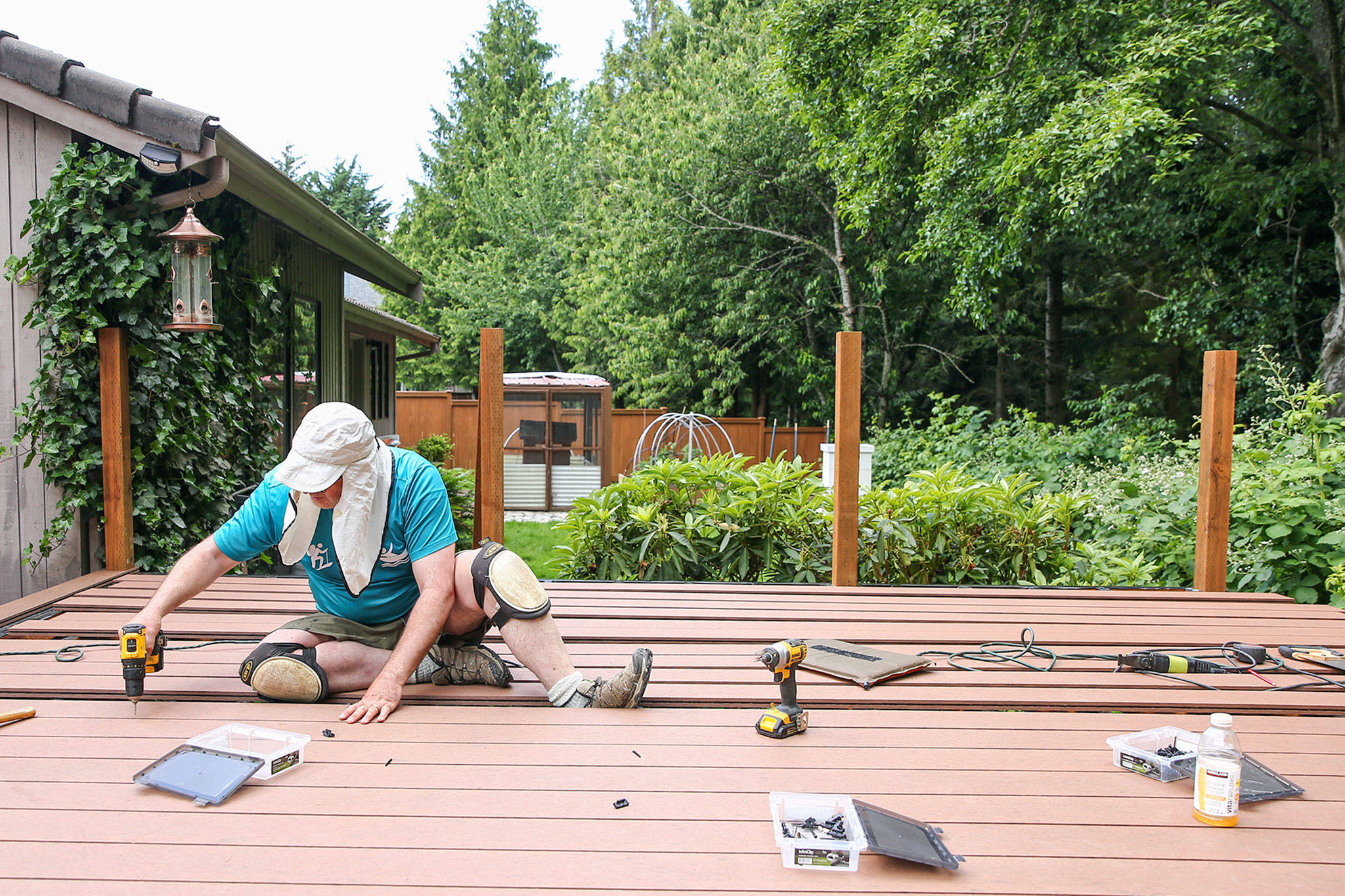 Rich Davis works on the deck of his home in Mukilteo on June 11. The deck isn’t 100% finished, but is far enough along for the Davis family to use it. (Kevin Clark / The Herald)