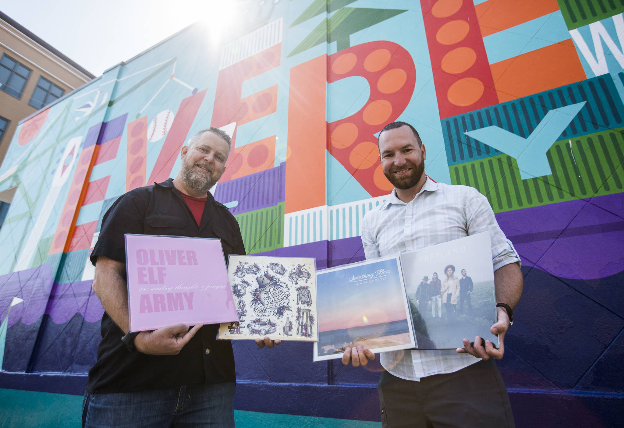 Brooks Smothers (left) and Ryan Taylor of Upper Left Records hold a handful of albums they will be selling, featuring local musicians from Everett to Stanwood. (Olivia Vanni / The Herald)