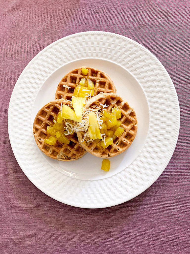 Crispy, golden pina colada waffles incorporate pineapple, toasted coconut and hazelnuts, with a topping of pineapple sauce for a warm, flavorful bite. (Lauren J. Mapp / The San Diego Union-Tribune)
