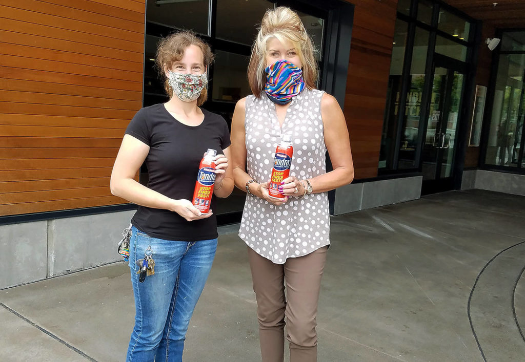 Tessa Long (right) is delivering 70 fire extinguishers to Hope Works Station employee Zoe Waltzlaka (left). (Everett Elks
