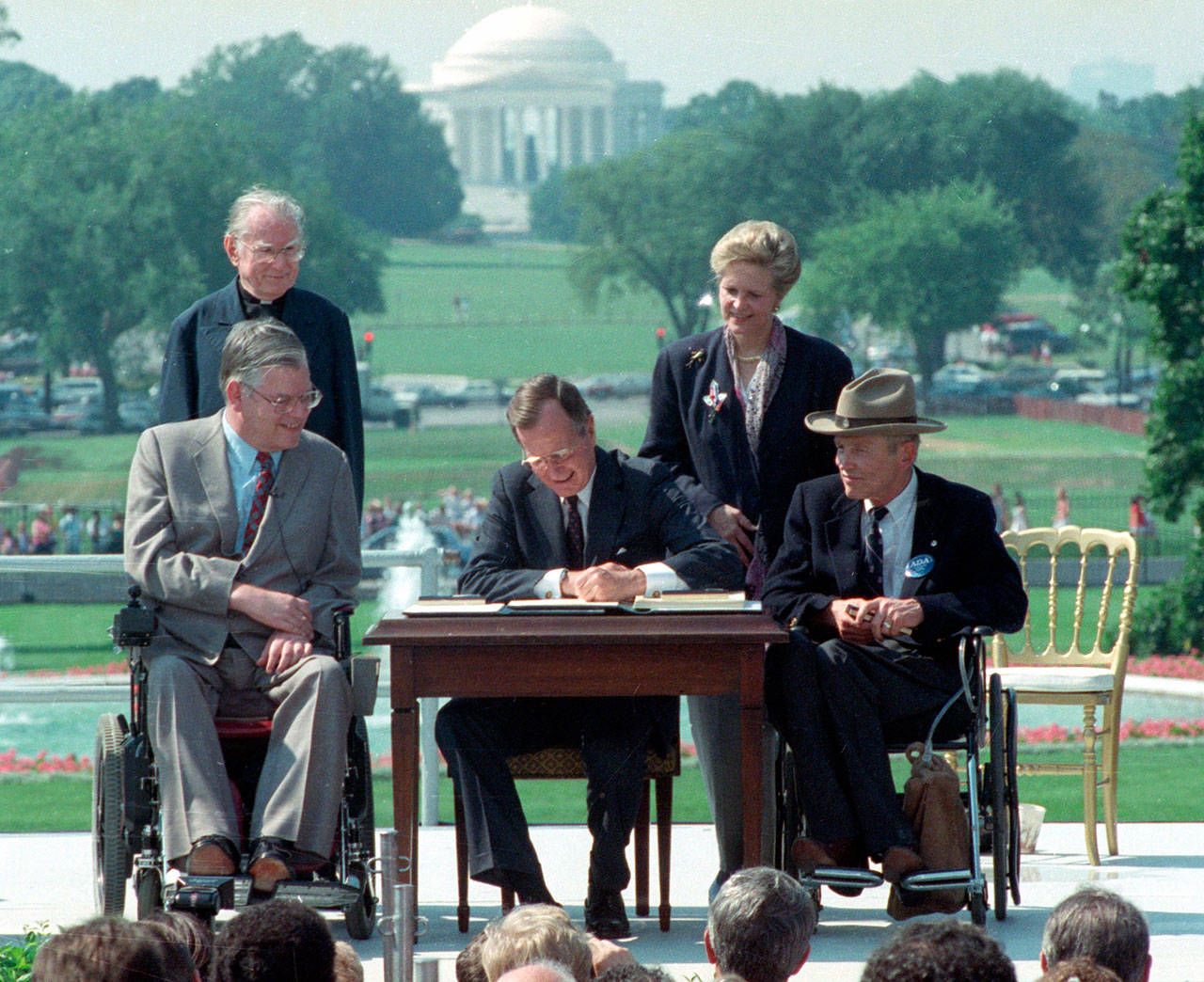 President George H.W. Bush signs the Americans with Disabilities Act during a ceremony on the South Lawn of the White House on July 26, 1990. Joining the president are (from left) Evan Kemp, chairman of the Equal Opportunity Employment Commission; the Rev. Harold Wilke; Sandra Parrino, chairman of the National Council on Disability, and Justin Dart, chairman of The President’s Council on Disabilities. (Barry Thumma / Associated Press file photo)