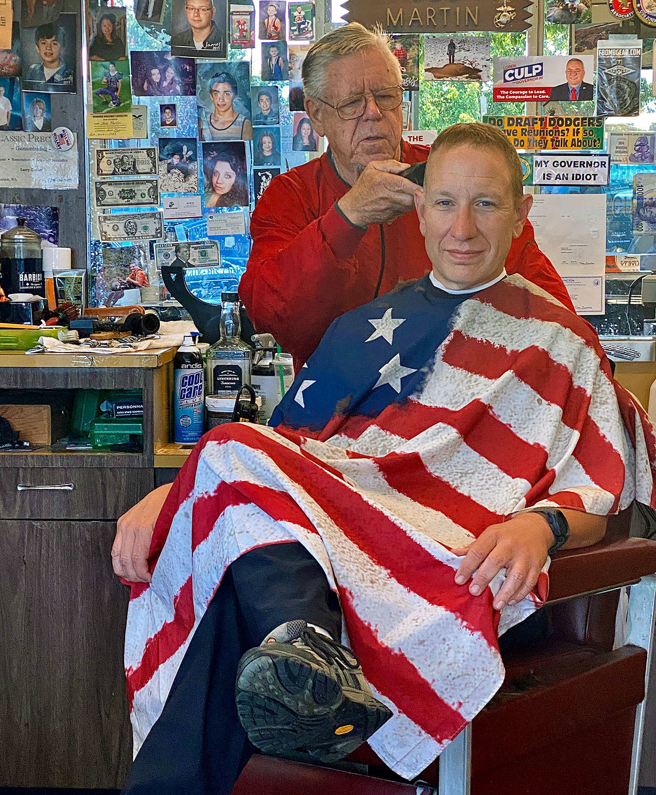 Barber Bob Martin (left) cuts the hair of a customer who declined to identify himself on Thursday in Snohomish. (Andrea Brown / The Herald)
