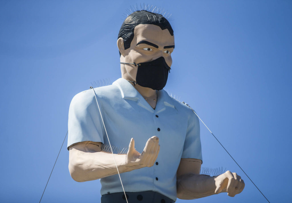 Everett’s Muffler Man statue atop a building on Hewitt Avenue wears a custom face mask. (Olivia Vanni / The Herald)
