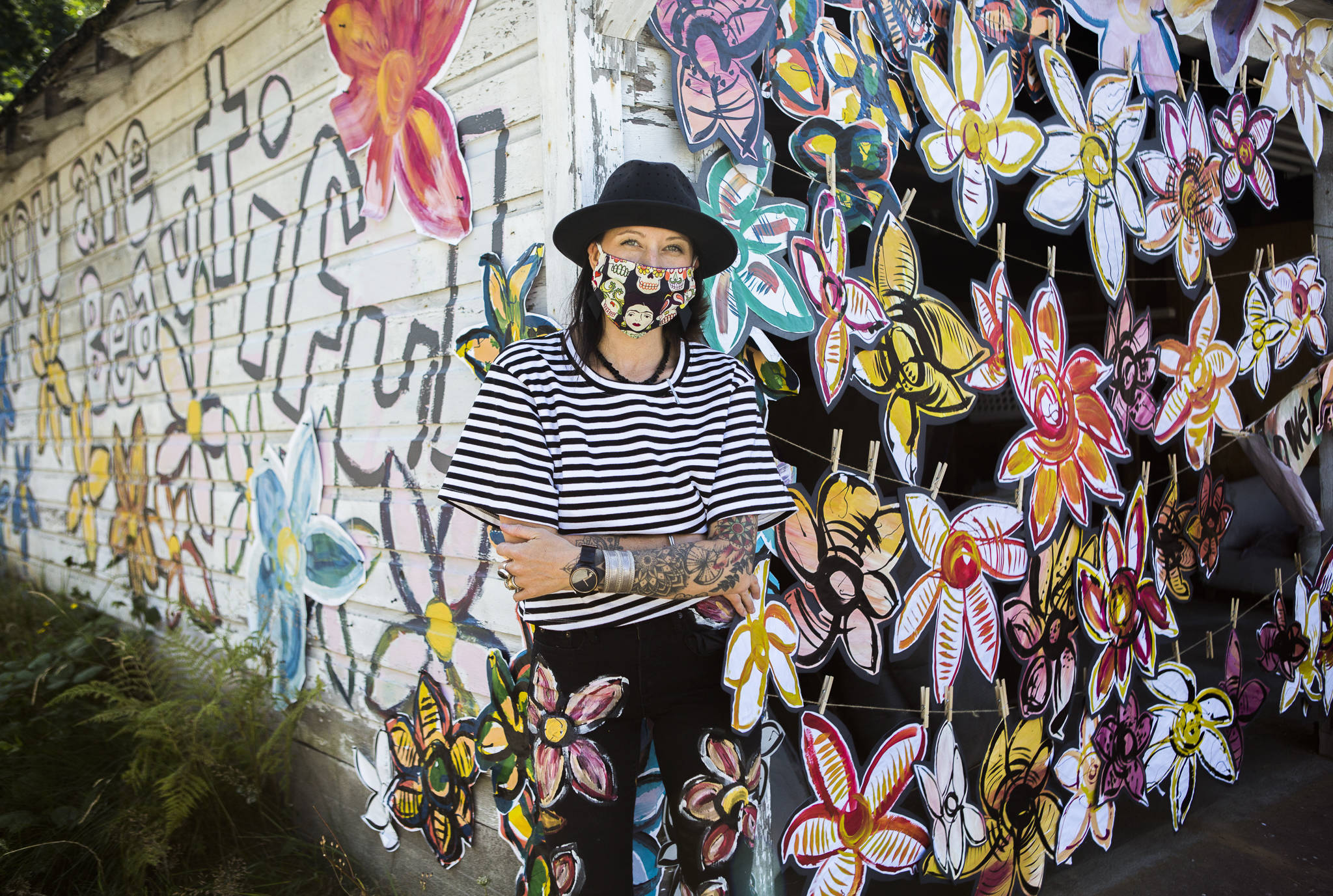 Artist Lennon Wiltbanks flowers decorate the garage of a vacant home in downtown Bothell. She says she hopes to spread joy in her neighborhood. (Olivia Vanni / The Herald)