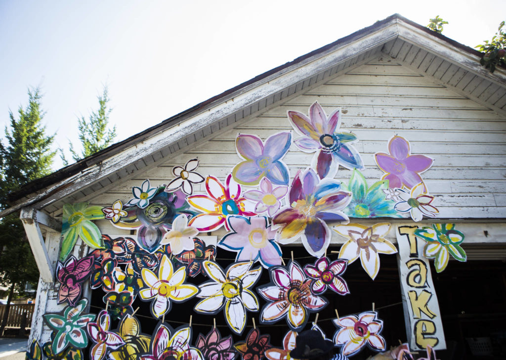 Lennon Wiltbank&rsquo;s flowers adorn the garage of an abandoned and soon-to-be-demolished home in downtown Bothell. (Olivia Vanni / The Herald)
