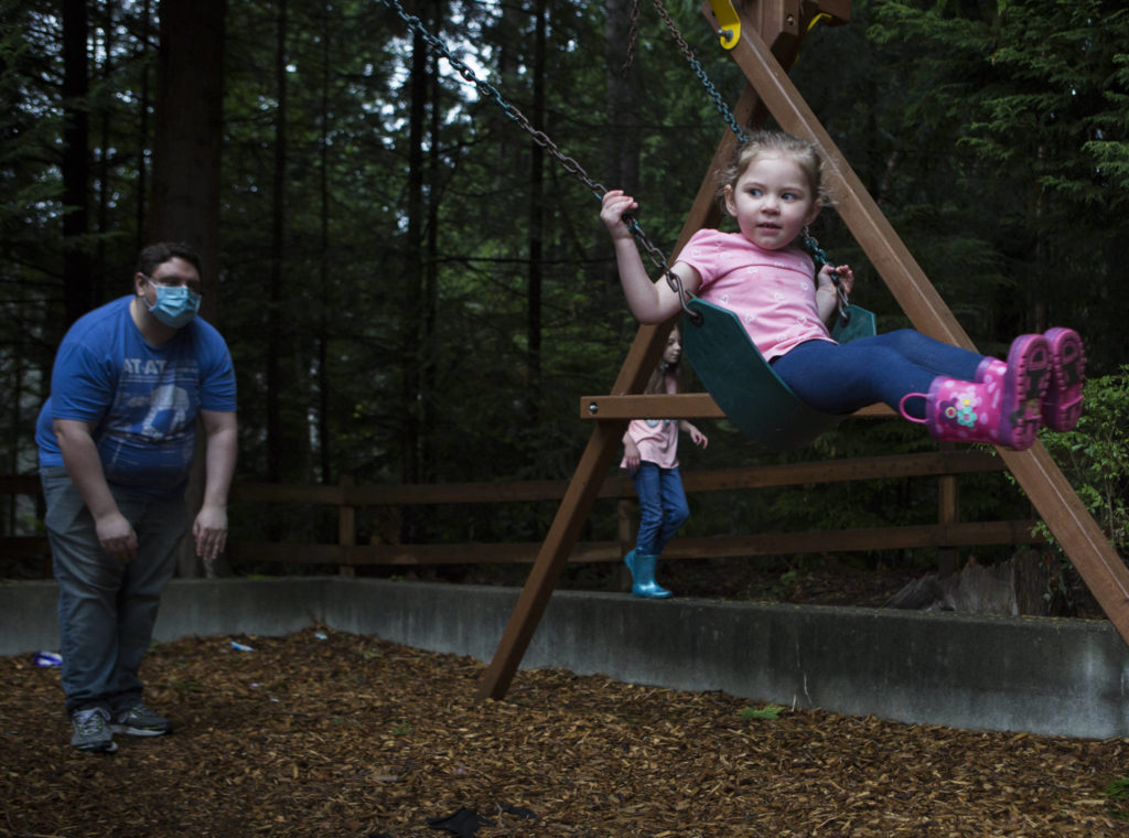 Ella Dunning, 3, is pushed on a swing Thursday by her dad, David Dunning, in Everett. Ella will start the online Early Childhood Education and Assistance Program in a few weeks. (Olivia Vanni / The Herald)
