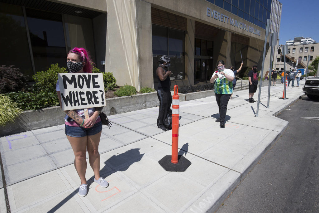 Sabrina Votry stands with a dozen protesters outside the Everett Municipal Building on Wednesday to protest homelessness and sweeping of camps. (Andy Bronson / The Herald)
