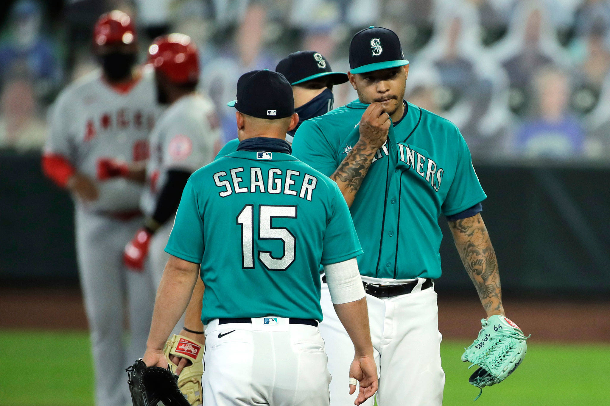 Mariners starting pitcher Taijuan Walker (right) waits with teammates to be pulled from the game in the fourth inning of a game against the Angels on Aug. 6, 2020, in Seattle. (AP Photo/Ted S. Warren)