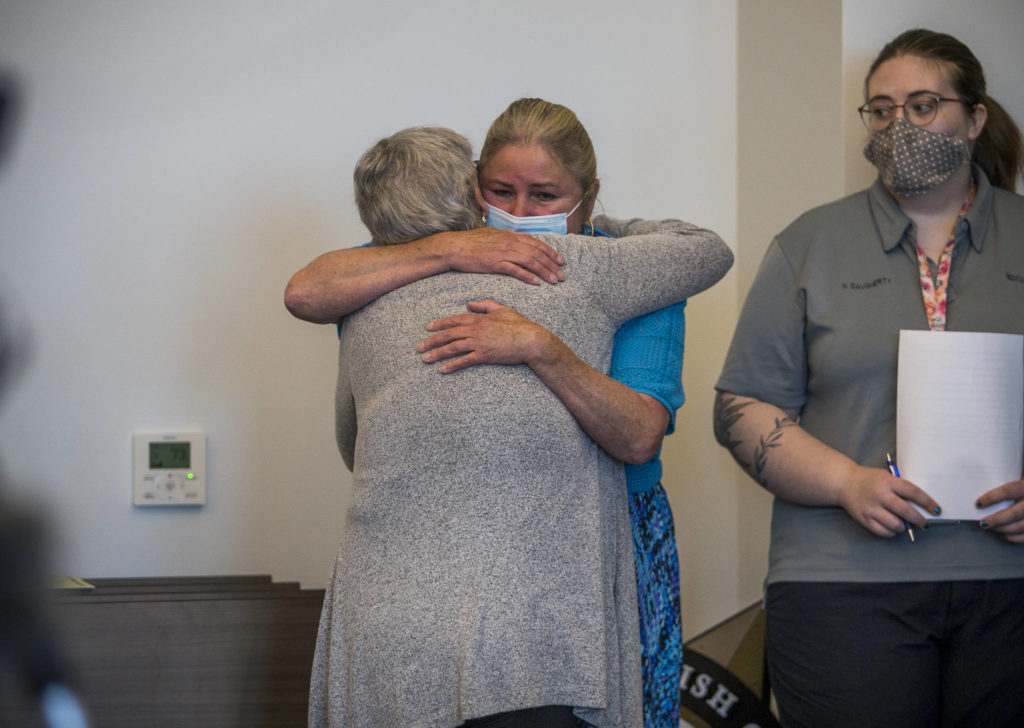 Eleanore “Ellie” Perry (right) hugs Marianne Lambert during a news conference on Wednesday in Everett. Perry is the cousin of Rodney Peter Johnson and Lambert is his sister. (Olivia Vanni / The Herald)
