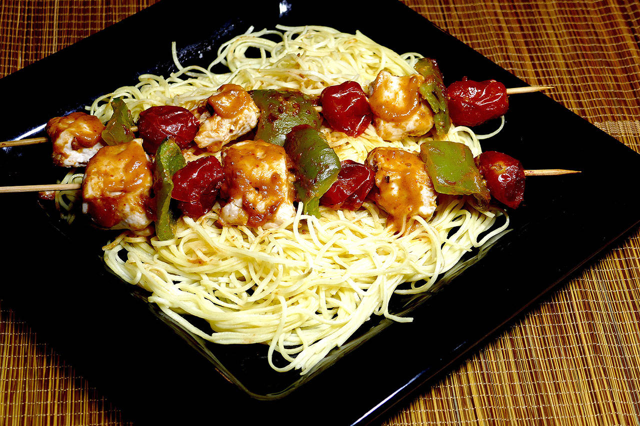 Peanut-flavored sauce with a slightly spicy edge flavors these Thai chicken kabobs with noodles. (Linda Gassenheimer)
