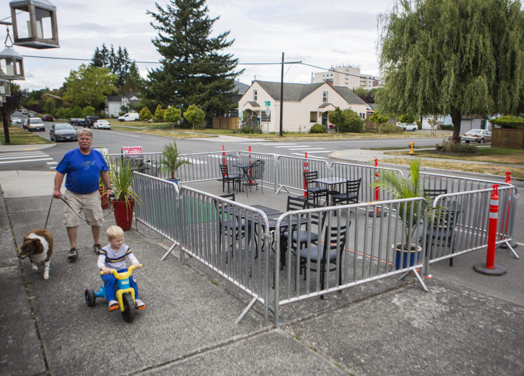 People walk by the new dining area outside of Cafe Zippy along Rucker Avenue on Thursday in Everett. Cafe Zippy is one of a handful of Everett businesses to apply for the new “streatery” program. (Olivia Vanni / The Herald)
