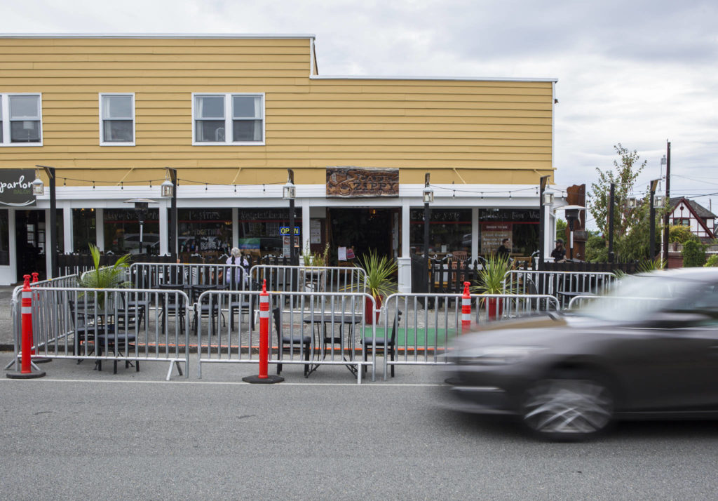 Cars drive by the “streatery” area outside of Cafe Zippy along Rucker Avenue on Thursday in Everett. (Olivia Vanni / The Herald)
