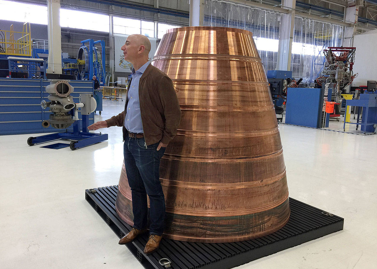 Amazon.com founder Jeff Bezos stands next to an exhaust nozzle during a media tour of Blue Origin in Kent in 2016. (AP Photo/Donna Blankinship)