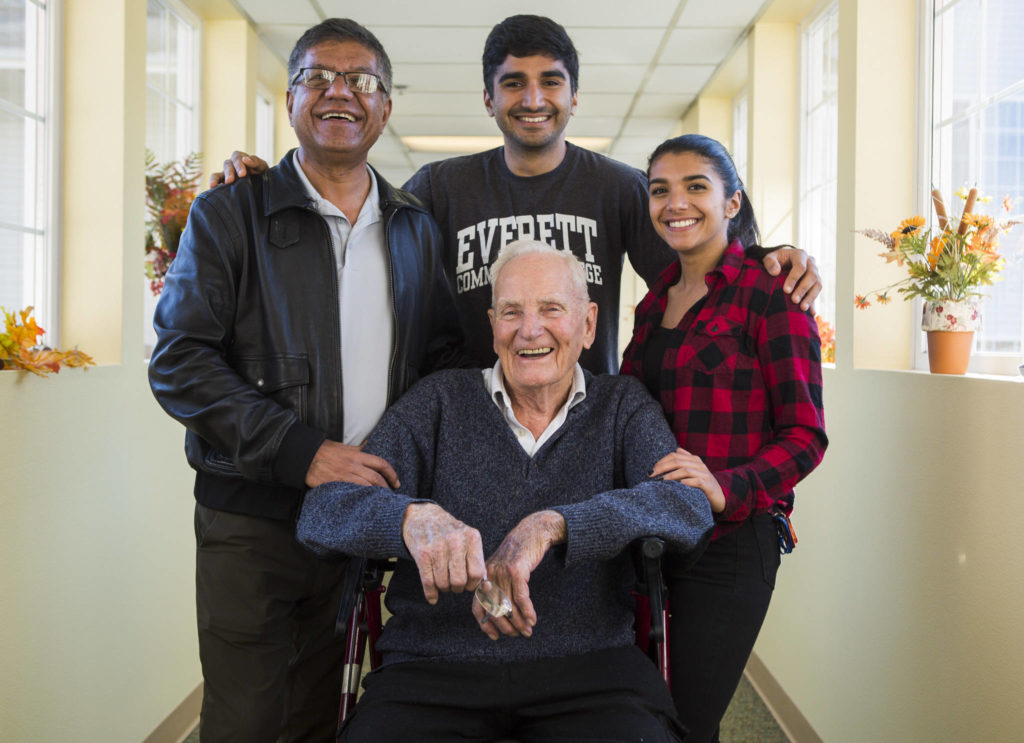 Bill Deller (center) with former student Mohammed Vahid Bahreini (left) and his two children Kaveh Danesh, 29, and Bahareh Danesh (right), 23, at Washington Oakes on Oct. 26, 2019, in Everett. (Olivia Vanni / Herald file) 
