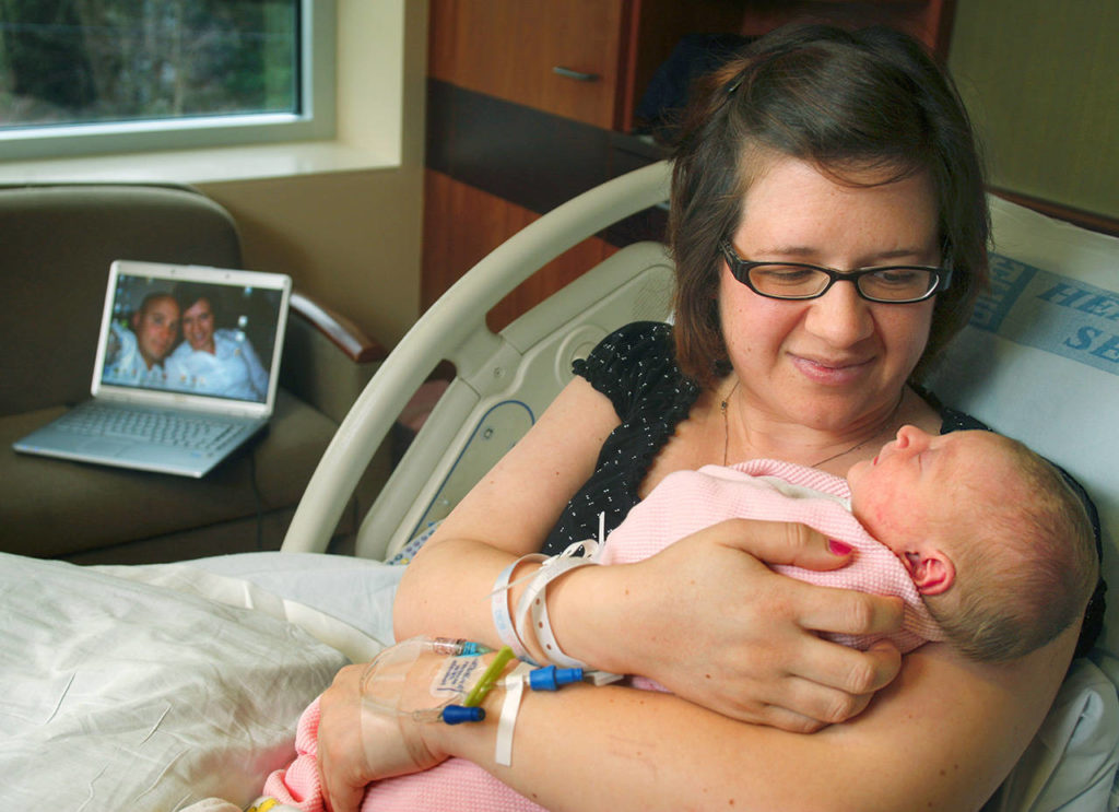 Mary Kay Jurovcik cuddles her newborn girl, Aubree, in February 2009 at Providence’s Pavilion for Women and Children in Everett. Jurovcik’s husband, Josh, was in Iraq, but watched the birth of his first daughter over the internet. (Dan Bates / Herald file)
