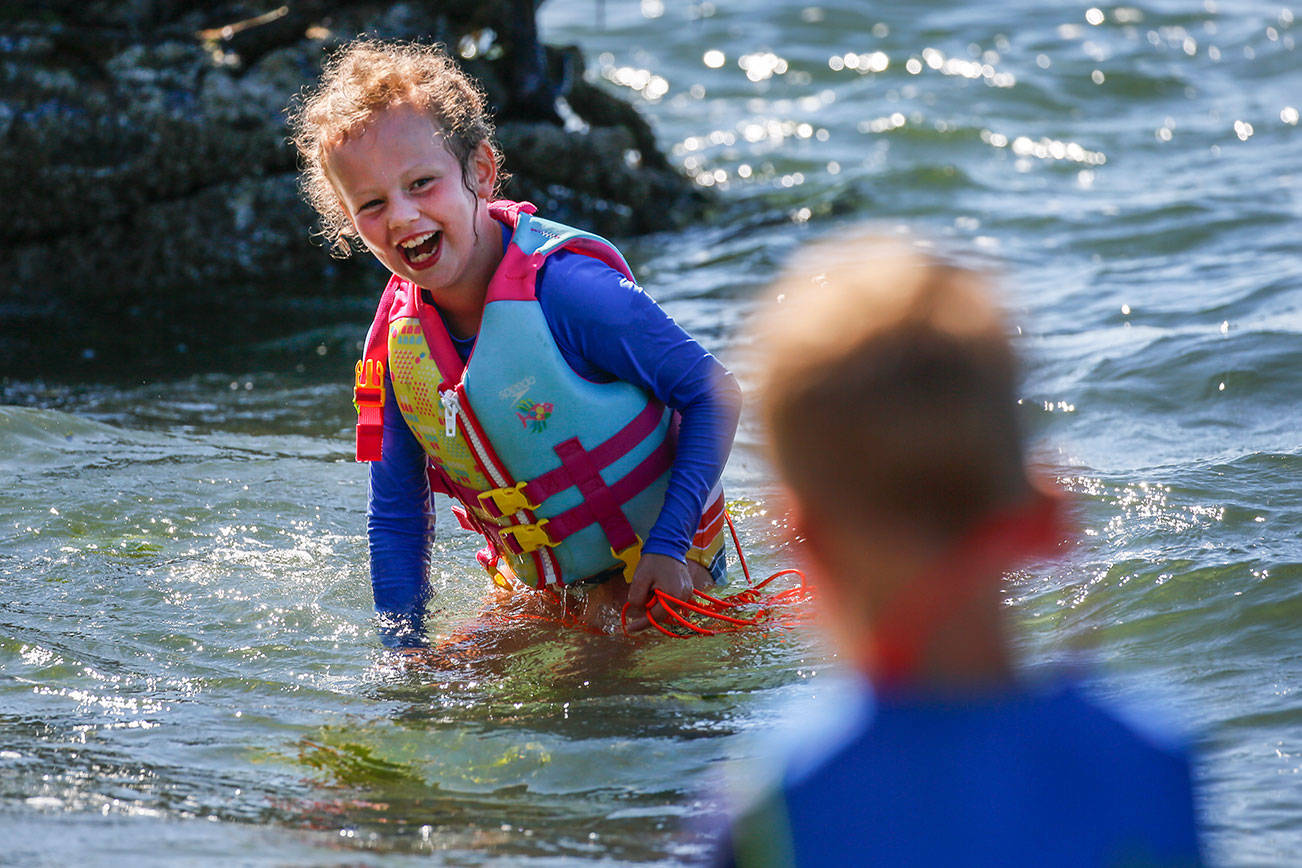 Piper Hounsel, 7, (left) shares a laugh with her brother Weston Hounsel, Friday afternoon in the waters off Howarth Park in Everett on August 14, 2020. (Kevin Clark / The Herald)