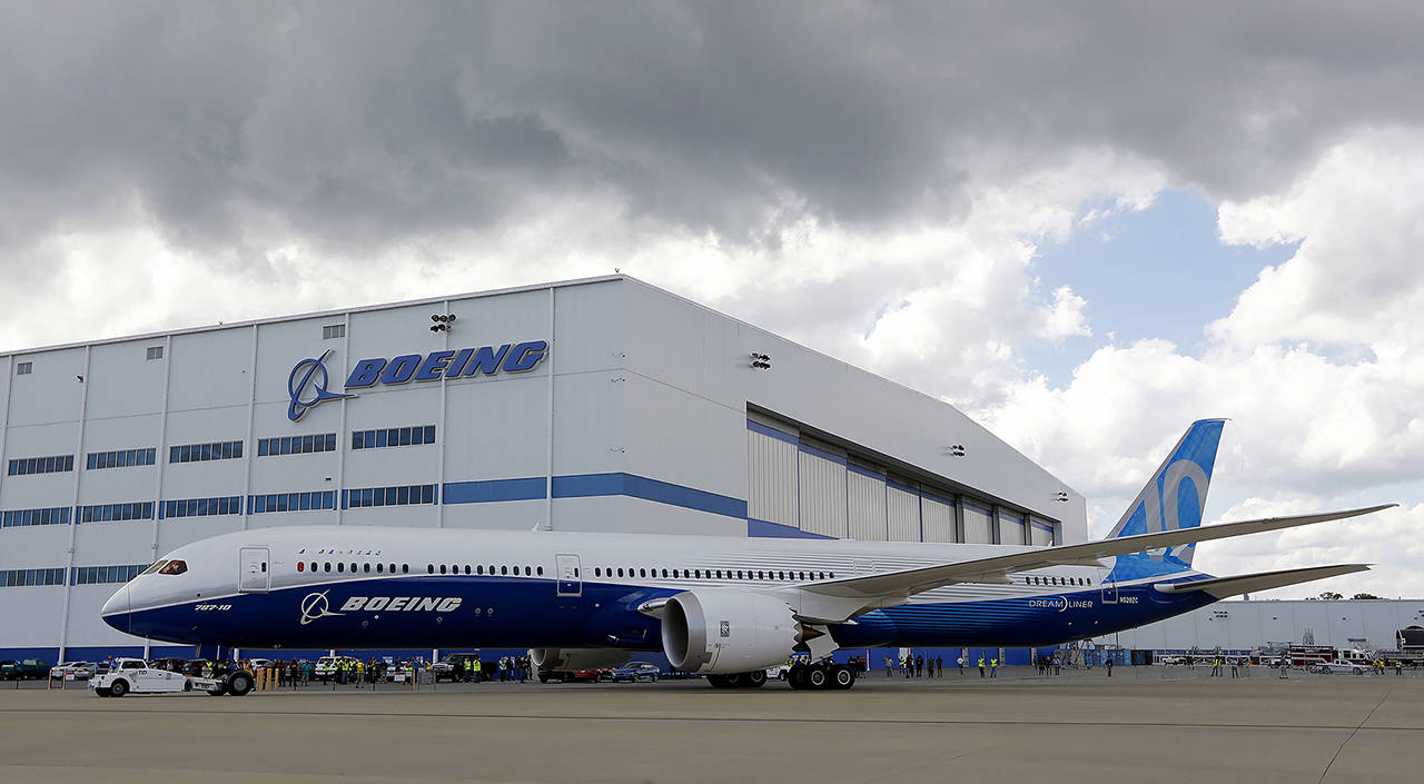 In this 2017 photo, Boeing employees stand near a new Boeing 787-10 at the company’s facility in North Charleston, South Carolina. (AP Photo/Mic Smith, File)