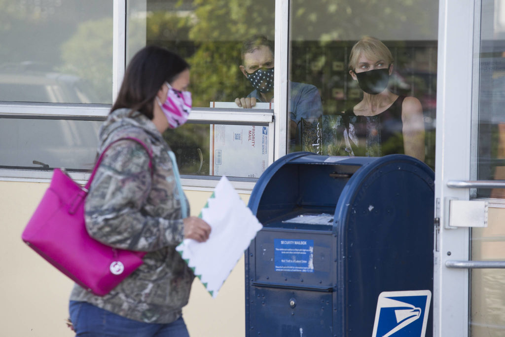 Customers at the U.S. Post Office on Hoyt Avenue in Everett on Tuesday. (Andy Bronson / The Herald)
While Reps. Rick Larsen (WA-02) and Suzan DelBene (WA-01) along with Jason Behrens speak to the media, customers use the US Post Office on Hoyt Avenue on Tuesday, Aug. 18, 2020 in Everett, Wa. Larsen and DelBene talked about the importance of the United States Postal Service (USPS) to Washingtonians and denounce President Trump’s efforts to slow down deliveries by the USPS and disenfranchise voters. (Andy Bronson / The Herald)
