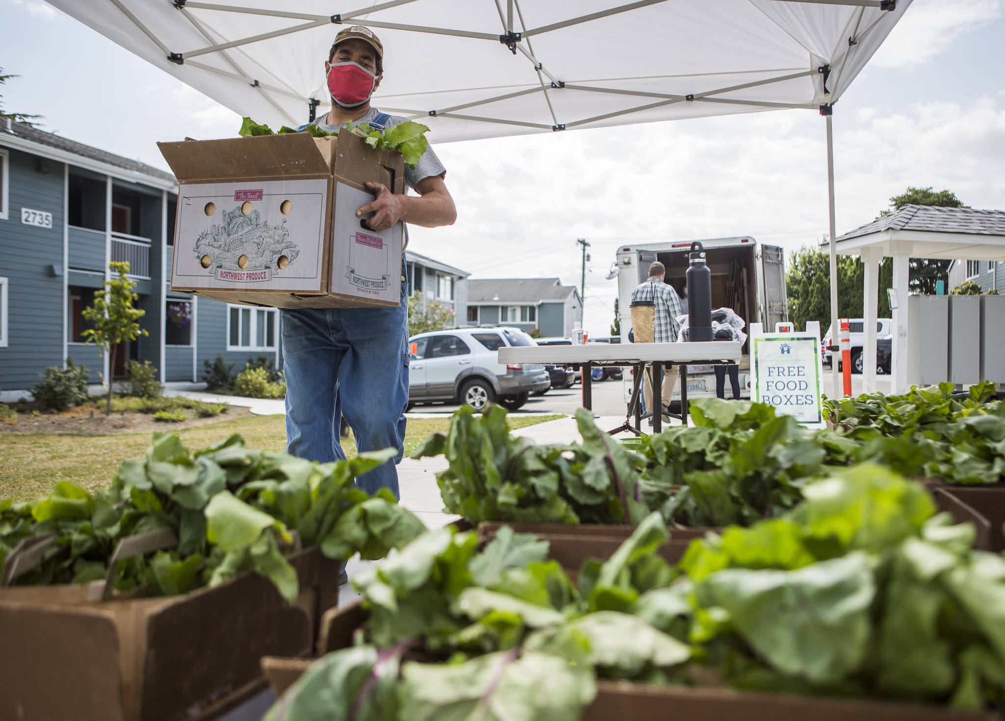 Vince Caruso of Caruso Farm in Snohomish delivers bags of his farm’s produce to Wiggums Park Place Apartments in Everett. (Olivia Vanni / The Herald)