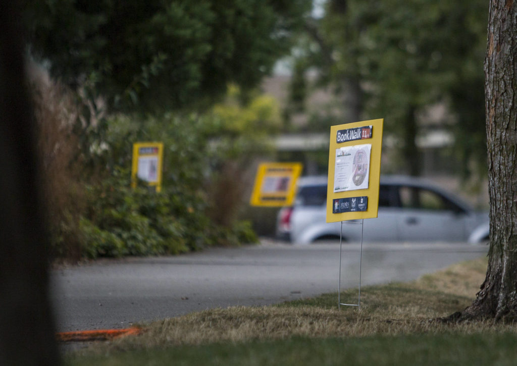 The book walk signs tell the tale of “Little Red Riding Hood” in two languages. (Olivia Vanni / The Herald)
