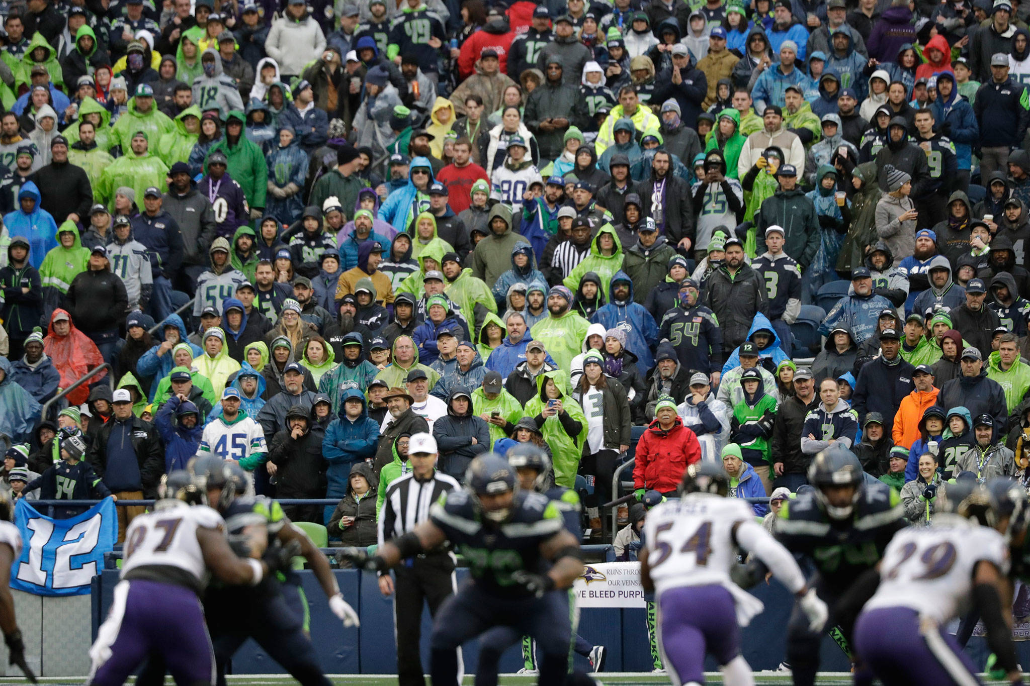 Seahawks fans stand in the rain during the second half of a game against the Ravens on Oct. 20, 2019, in Seattle. (AP Photo/Elaine Thompson)