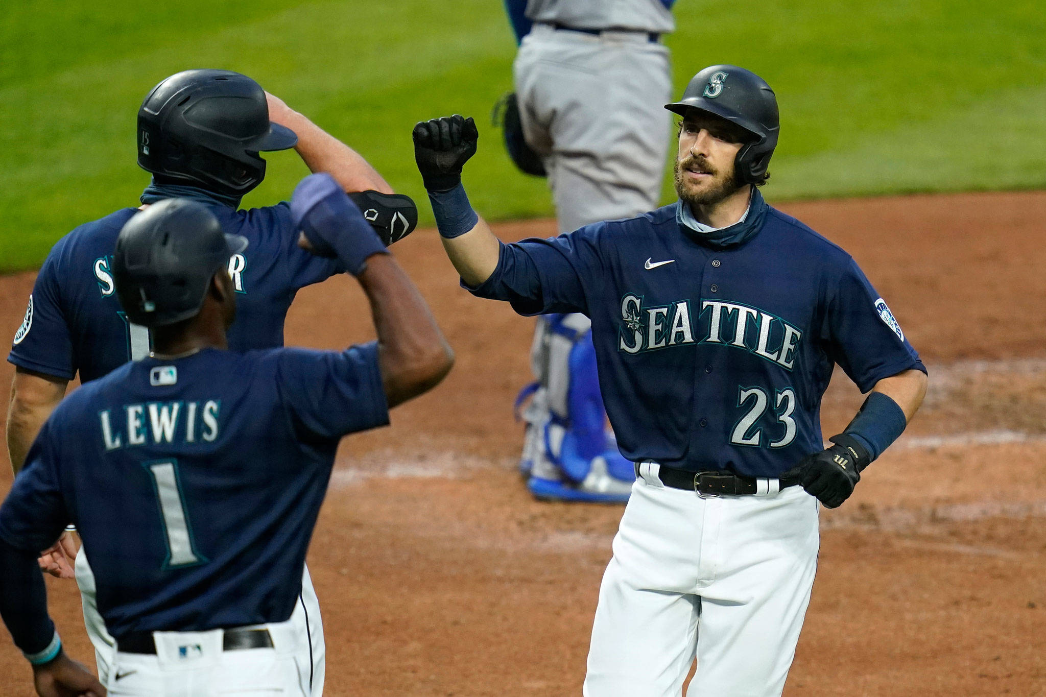 The Mariners’ Austin Nola (23) is greeted at home after his three-run home run by Kyle Lewis (1) and Kyle Seager during the third inning of a game against the Dodgers on Aug. 19, 2020, in Seattle. (AP Photo/Elaine Thompson)
