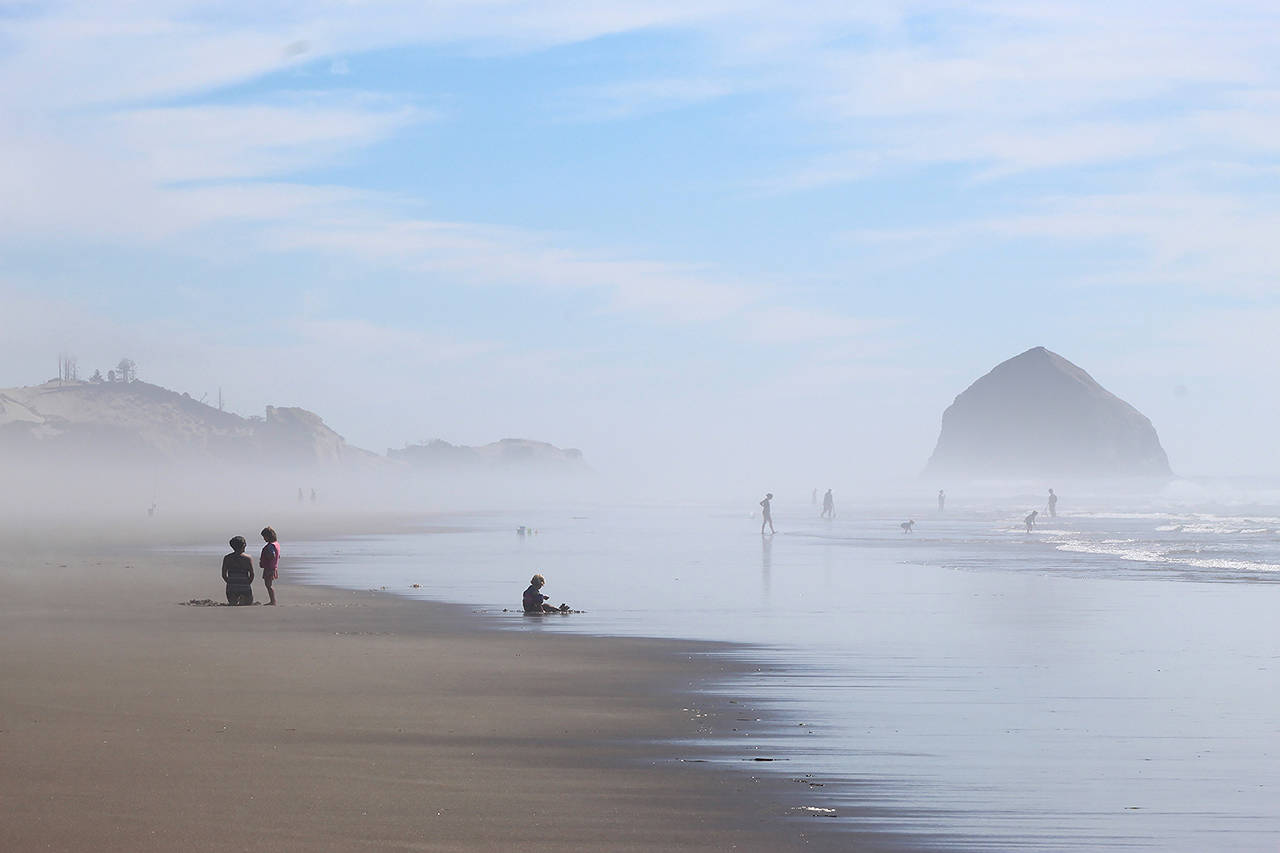 People walk on the beach near the Facebook cable landing site at Tierra del Mar, Oregon, on Aug. 17. (AP Photo/Andrew Selsky)