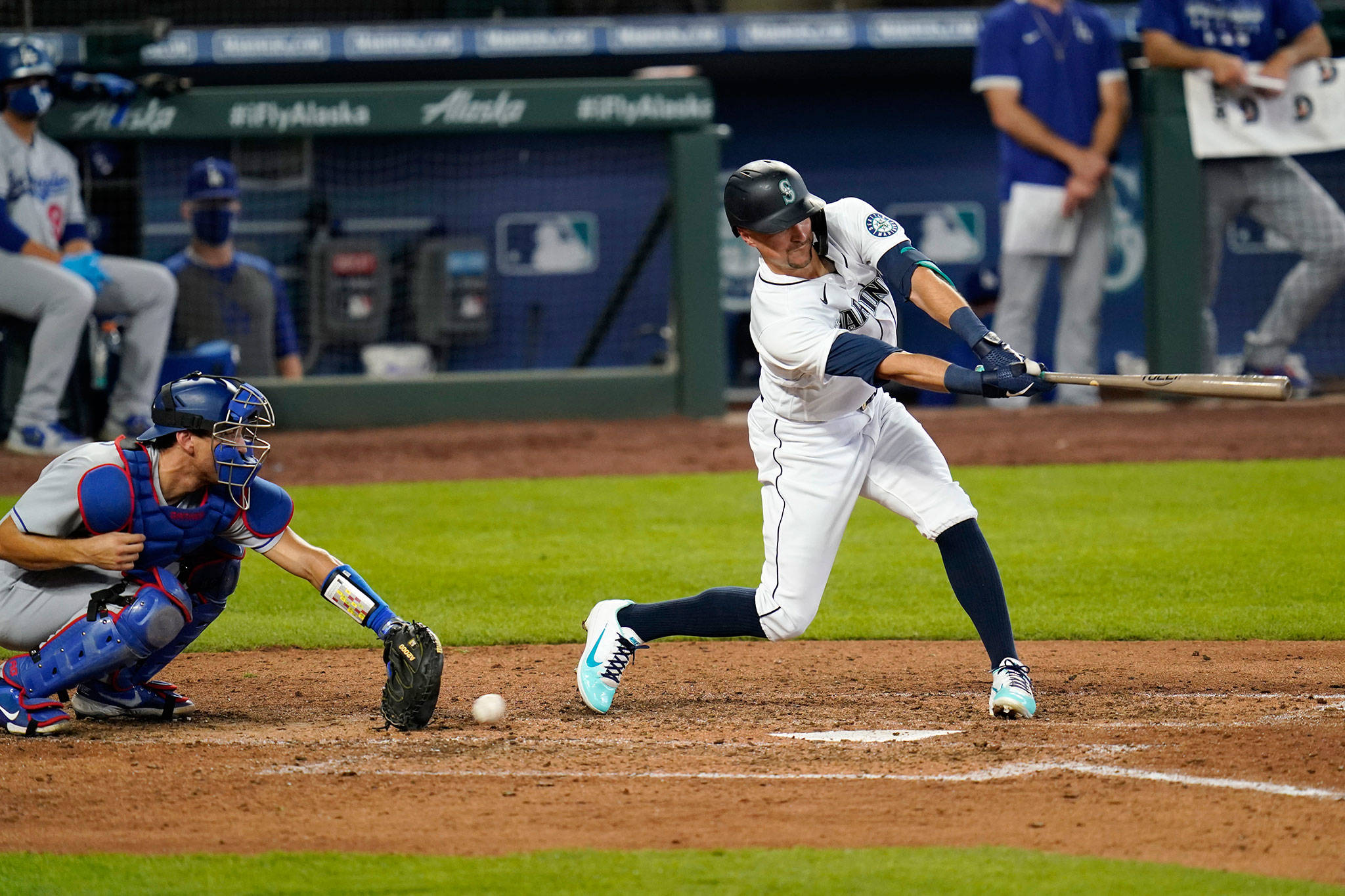 The Mariners’ Braden Bishop swings and misses as Dodgers catcher Austin Barnes reaches for the ball to end the seventh inning of a game Aug. 20, 2020, in Seattle. (AP Photo/Elaine Thompson)