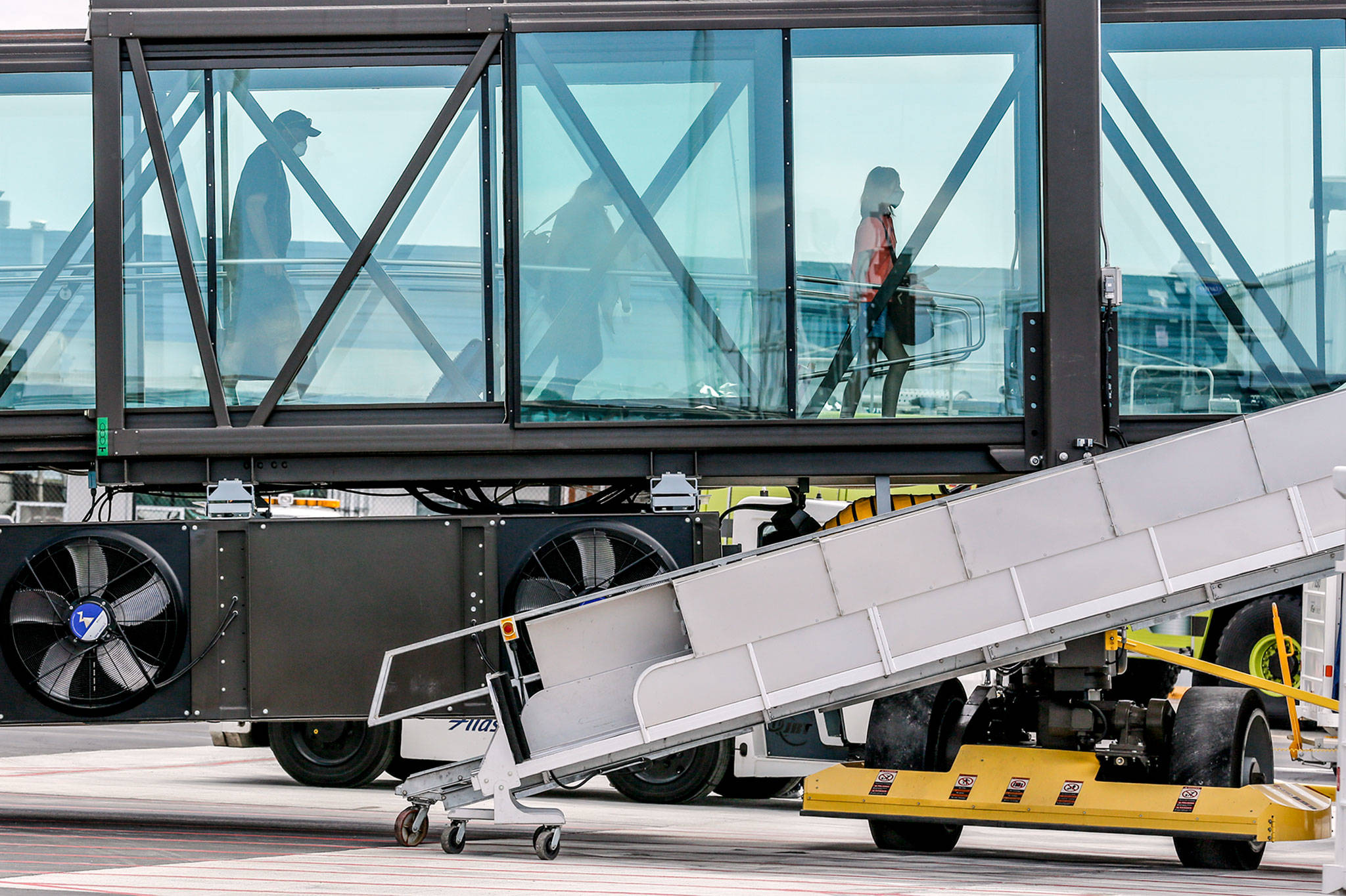 Denver-bound passengers board a flight at Paine Field in Everett on Aug. 1. (Kevin Clark / The Herald)