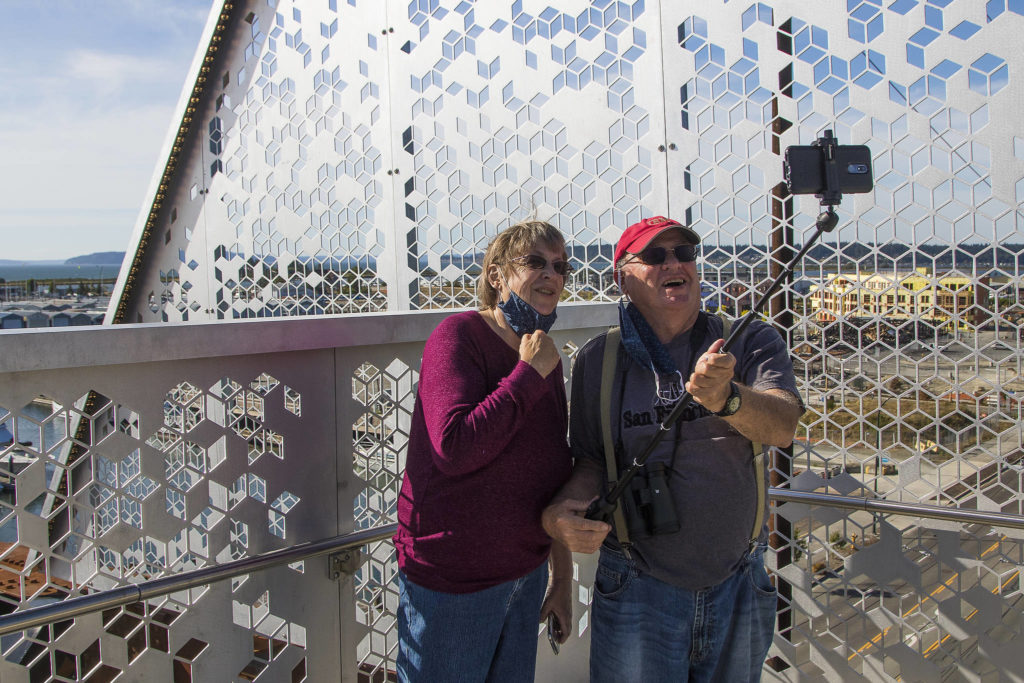 Marianne and Barry McWilliams take a photo together as they walk down the newly opened Grand Avenue Park Bridge on Wednesday in Everett. (Andy Bronson / The Herald)
