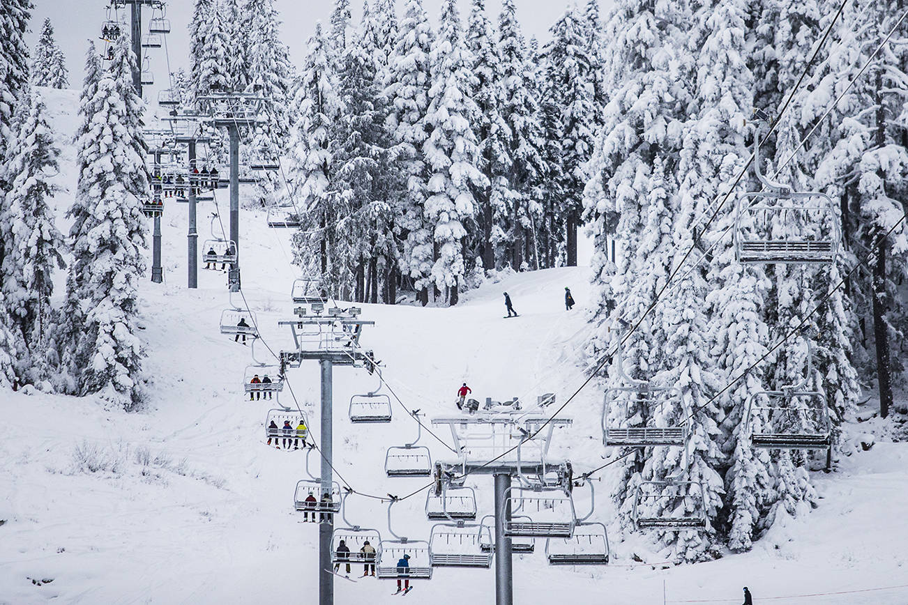 People ride the chair lifts as skiers and snowboarders make their way down the mountain during the opening day of Stevens Pass on Wednesday, Dec. 18, 2019 in Stevens Pass, Wash. (Olivia Vanni / The Herald).