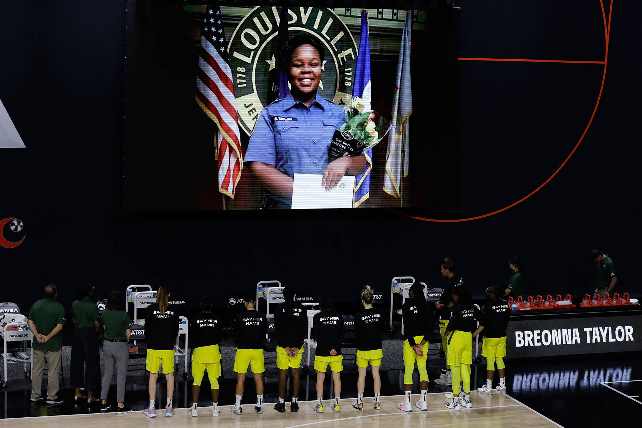 Members of the Storm stand in front of a photo of Breonna Taylor before a game against the Mystics on July 30, 2020, in Bradenton, Fla. Taylor was killed in her home by police officers. (AP Photo/Chris O’Meara)