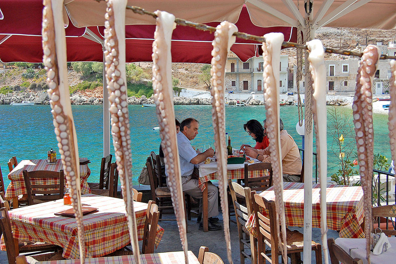 Octopus dries in the sun while diners enjoy a meal at a beachside restaurant. (Rick Steves’ Europe)