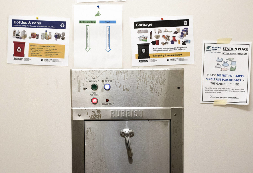 Garbage, recycling and compost are separated by residents by using different buttons for the garbage chute on each level of HopeWorks Station in Everett. (Andy Bronson / The Herald) 
