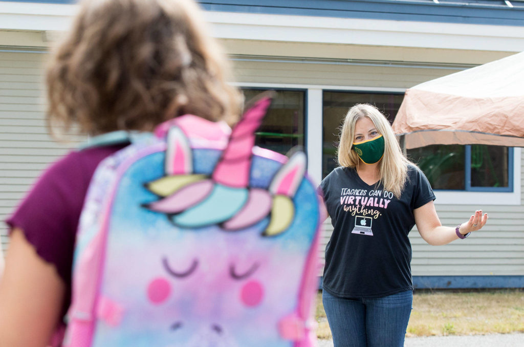 Darrington Elementary teacher Helen Ross talks with a former student as students and teachers meet outside on the first day of school Tuesday in Darrington. (Andy Bronson / The Herald)
