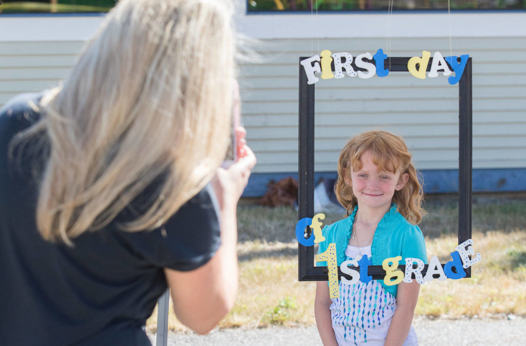 Emma Jayne gets a photo taken by teacher Helen Ross on the first day of school at Darrington Elementary. Students and teachers met outside the school due to COVID-19. (Andy Bronson / The Herald)
