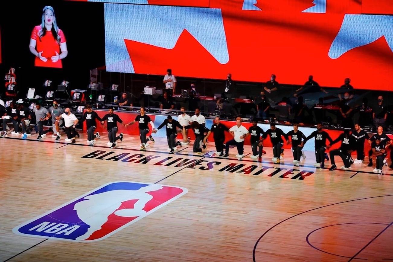 Players take a knee during the Canadian national anthem before an NBA basketball game between the Toronto Raptors and the Milwaukee Bucks on Aug. 10 in Lake Buena Vista, Fla. (AP Photo, Mike Ehrmann)