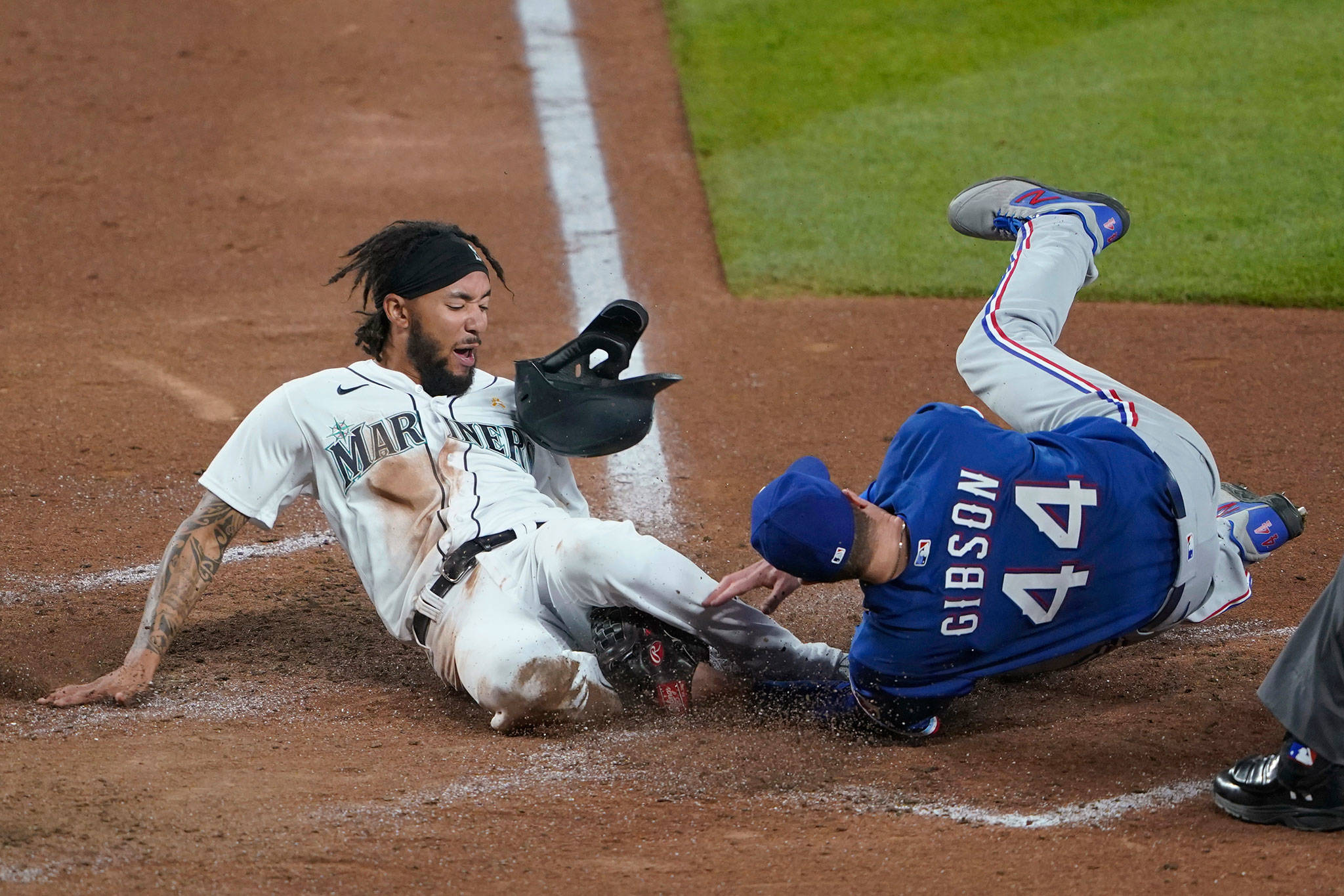 The Mariners’ J.P. Crawford (left) is out at home on a tag by Rangers starting pitcher Kyle Gibson as Crawford tried to score on a single by Dylan Moore during the fifth inning of a game Sept. 5, 2020, in Seattle. (AP Photo/Ted S. Warren)