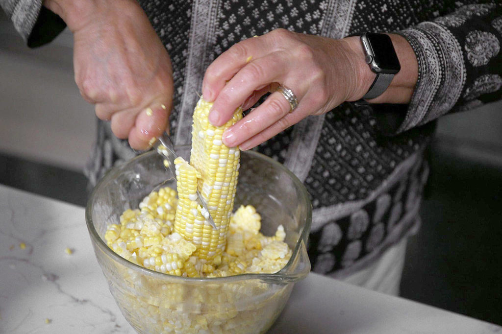 Cutting kernels from the cob can be a messy chore. But standing the ear up in a bowl means the kernels will gather there instead of all over your cutting board and countertop. (Terrence Antonio James / Chicago Tribune)
