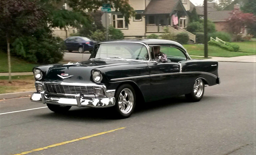 A shiny black Chevy brings the 1950s back to Rucker Avenue in north Everett as its driver joins Saturday’s informal cruise. (Julie Muhlstein / The Herald)
